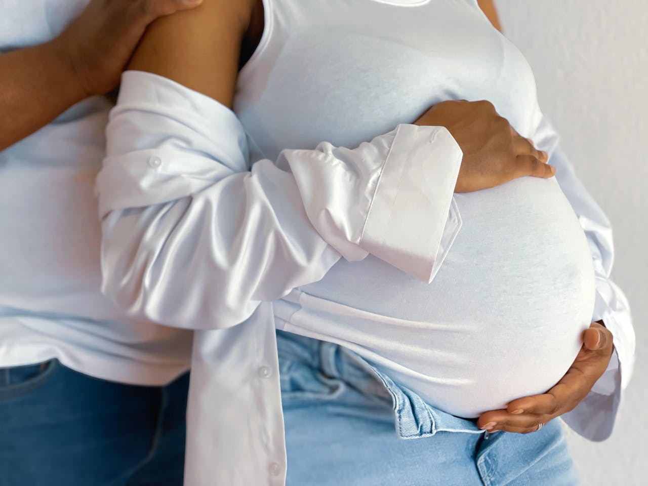 A close-up of a pregnant couple embracing, conveying love and anticipation.