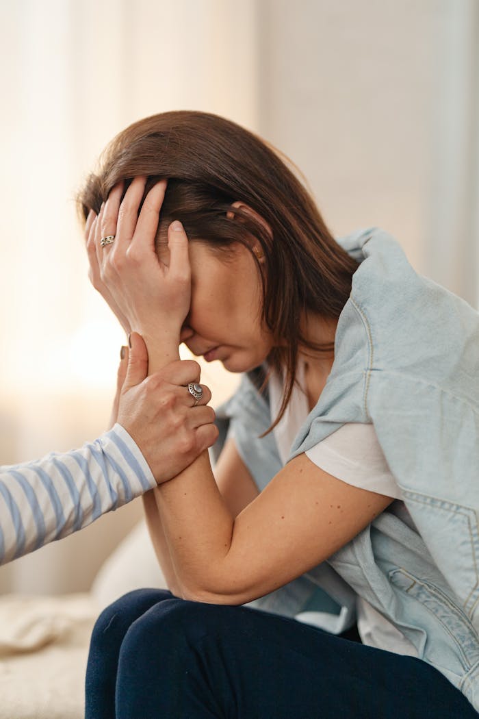 A woman receiving emotional support indoors. Comfort and empathy depicted.